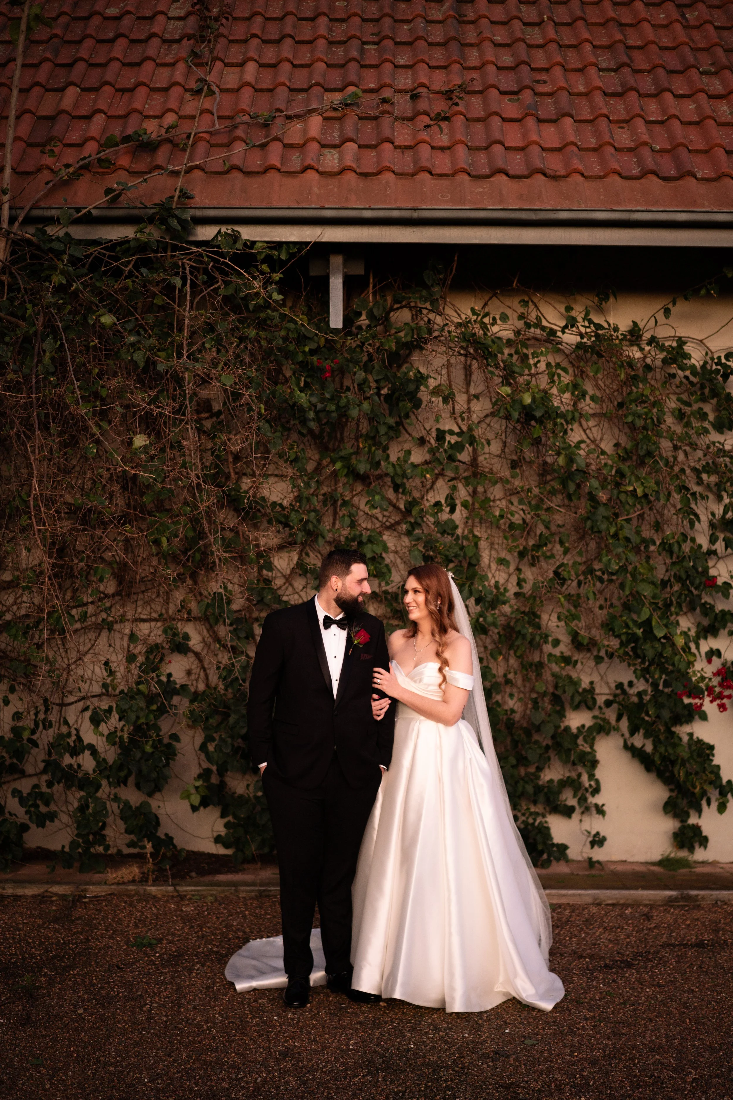 The couple in front of an ivy-covered wall