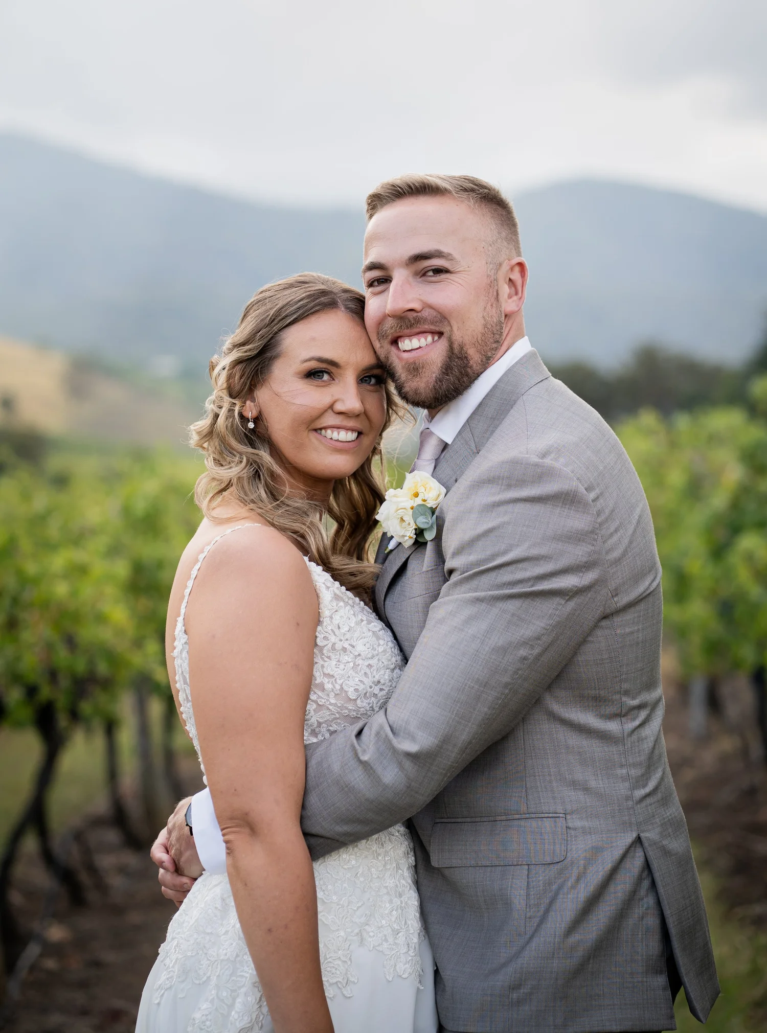 The couple in the vineyard with the mountains behind