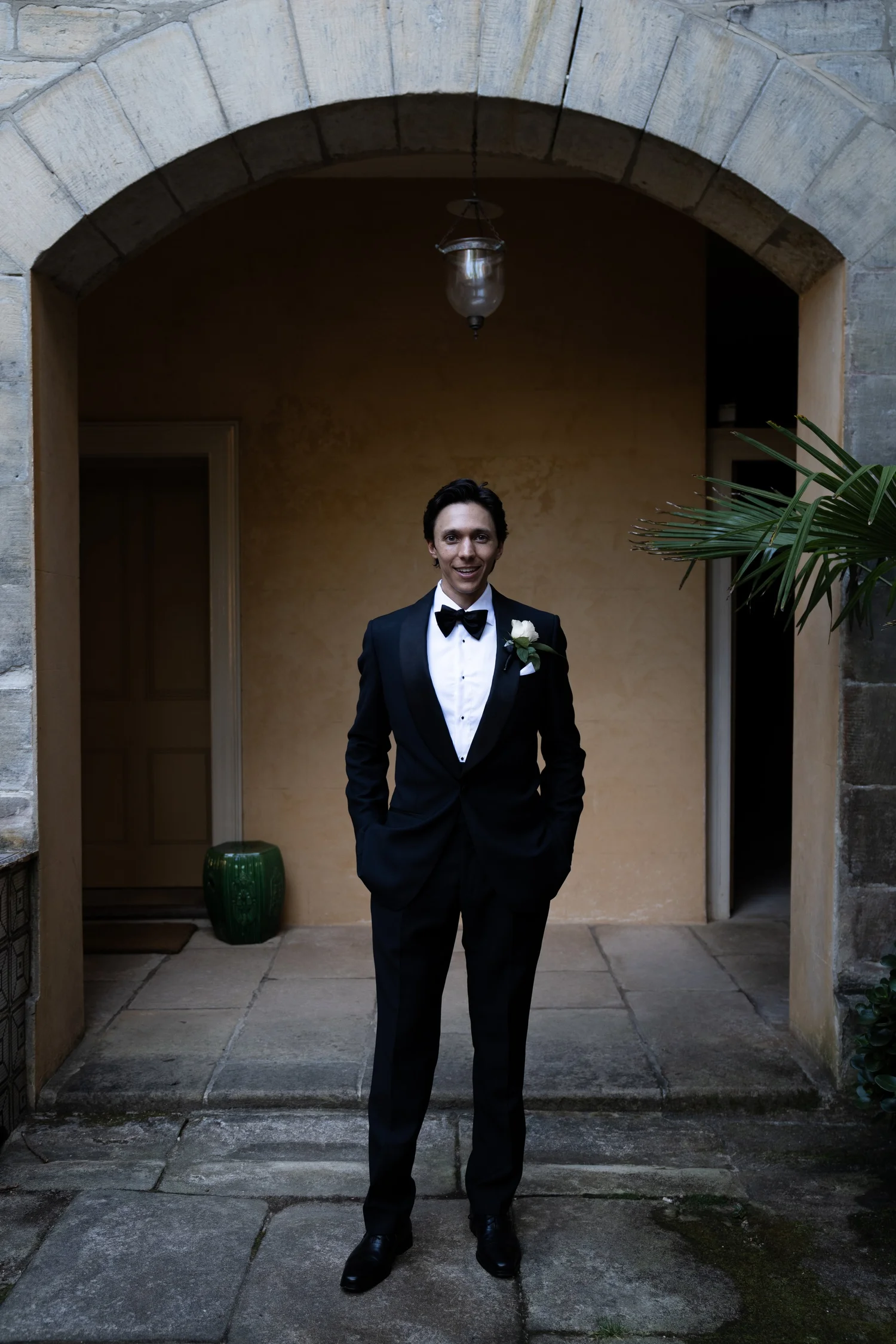 Portrait in a tuxedo under an archway. Kat & Aaryn's wedding at Vaucluse House, Sydney