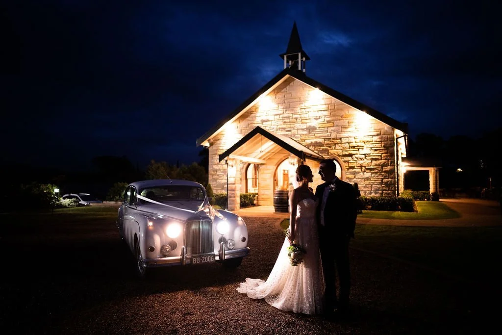 The chapel lit up at night with a vintage car. Wedding at Peterson House, Hunter Valley
