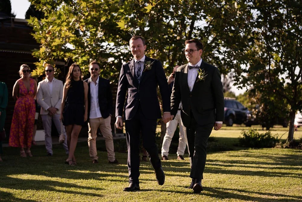 Walking up the aisle on the lawn. Aaron & Scott's wedding at Margan Wines, Hunter Valley