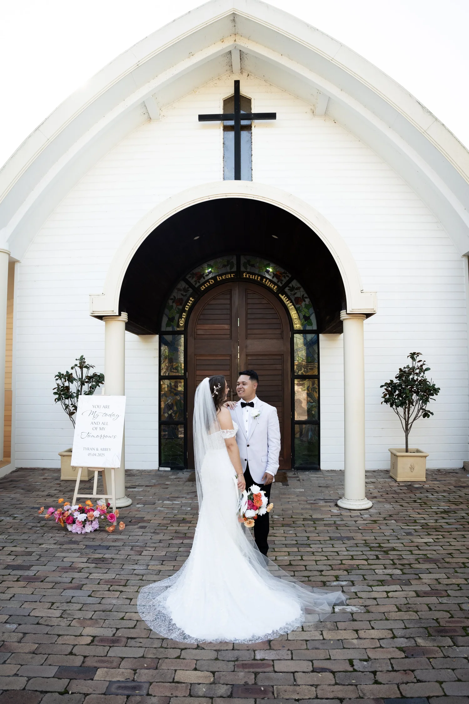 The couple outside the white chapel. Abbey & Tyran's wedding at Hunter Valley Gardens & Kirkton Park, Hunter Valley