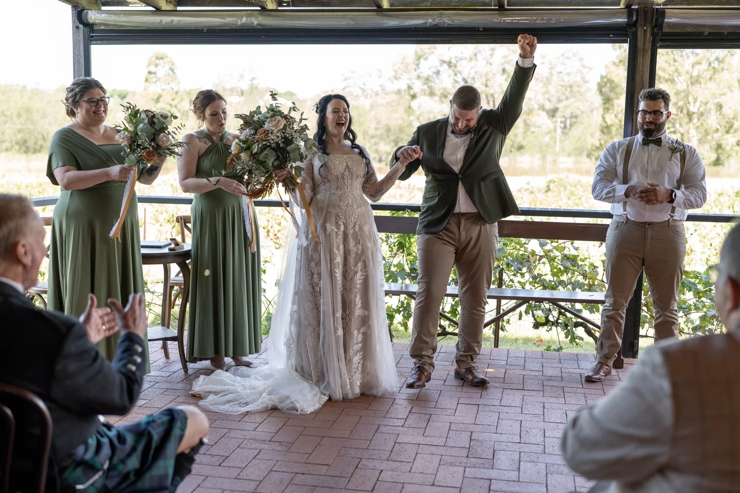 The newlyweds celebrate on the verandah. Alana & Peter's wedding at Peppers Creek, Hunter Valley