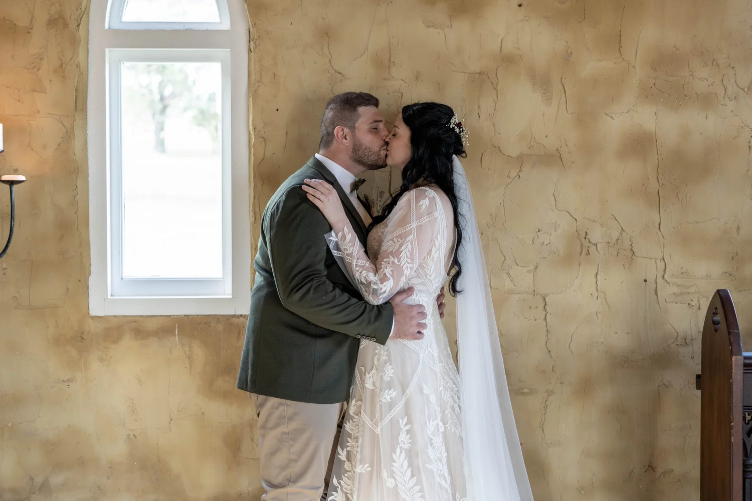 A kiss inside the stone chapel. Alana & Peter's wedding at Peppers Creek, Hunter Valley