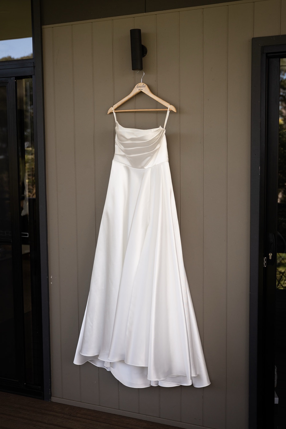 The wedding dress hanging on the door. Amelia & Connor's wedding at Glenworth Valley, Central Coast