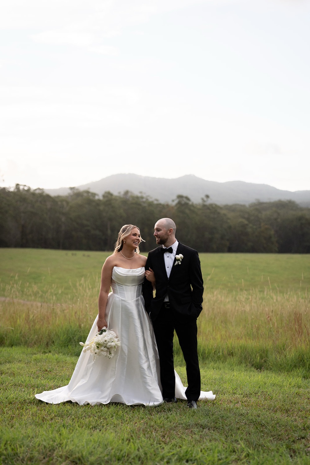 The couple in the field at dusk. Ashley & Justin's wedding at Haven Ridge, Grants Beach, Mid North Coast