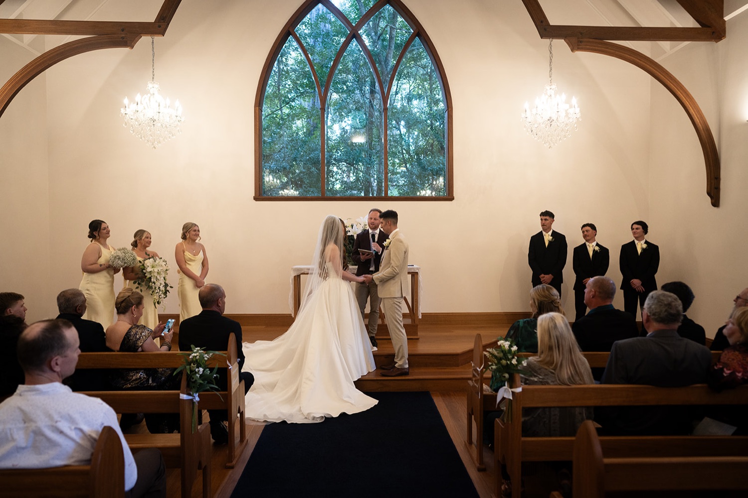The ceremony under the chapel's stained-glass window. Charlie & Lachlan's wedding at Kantara House, Central Coast