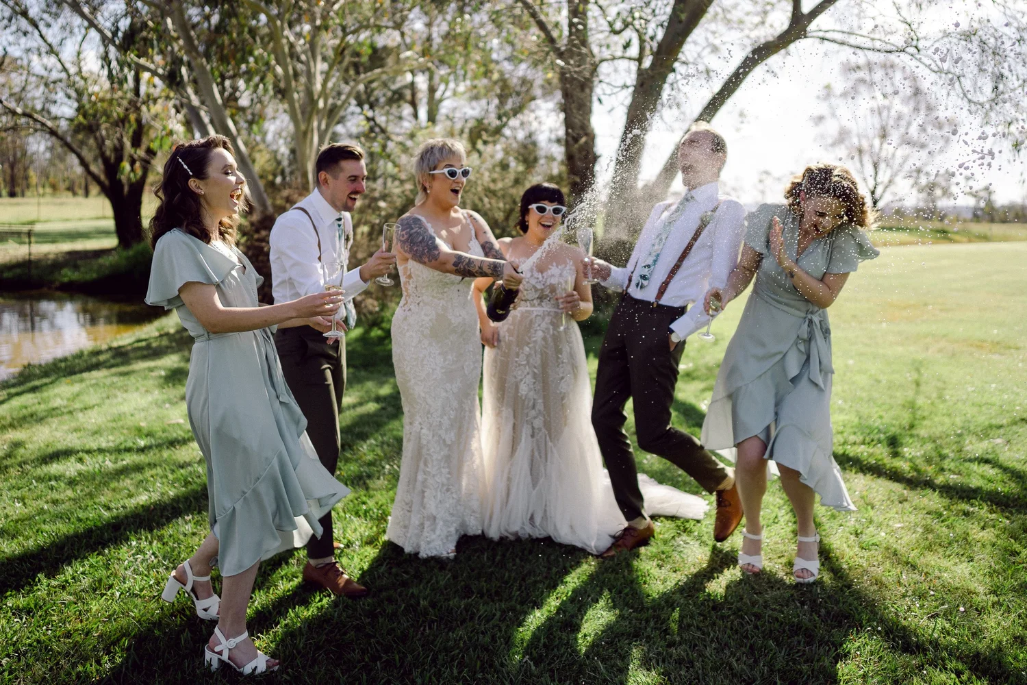 The wedding party laughing on the lawn. Daena & Inez's wedding at Collits Inn, Blue Mountains