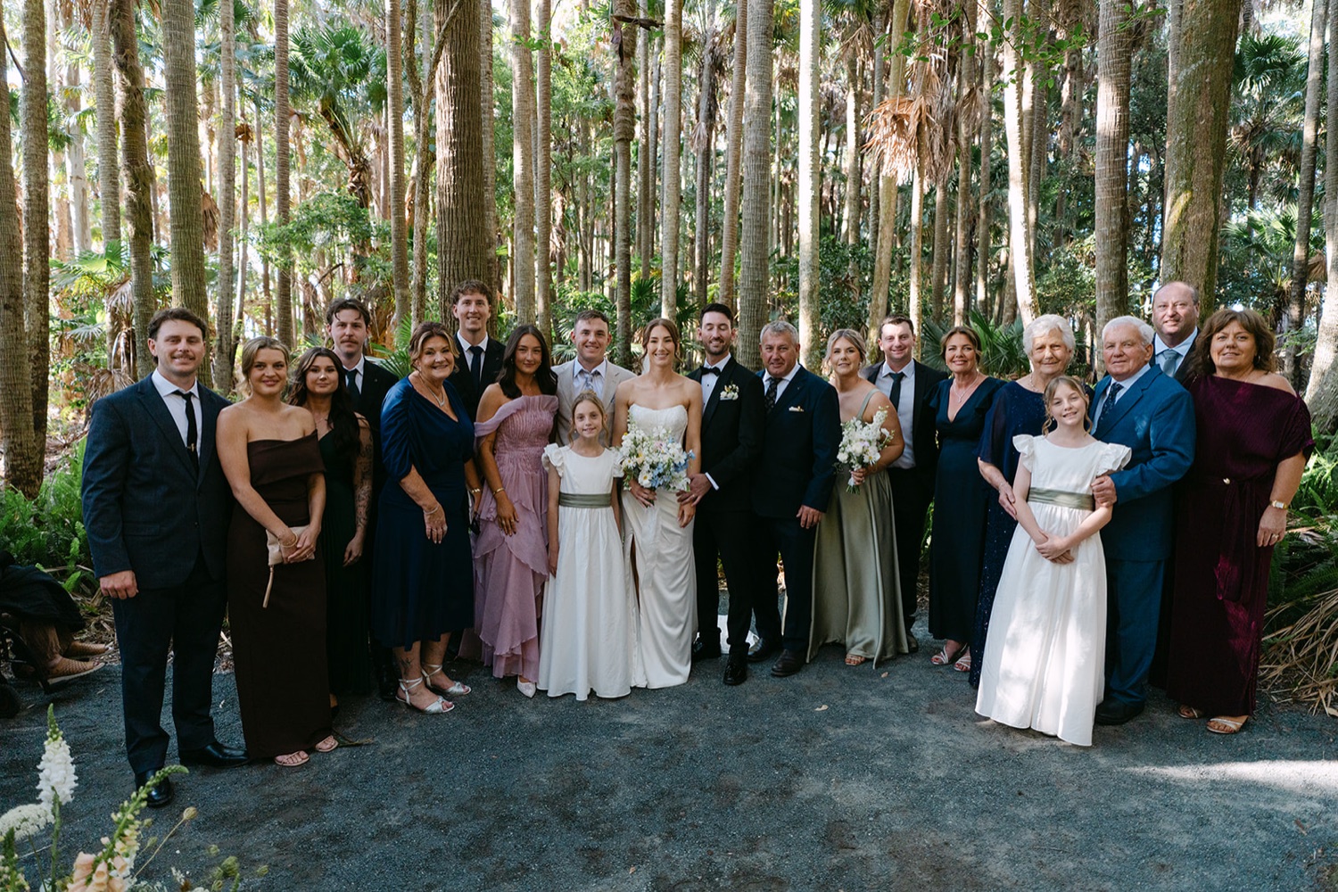 Group photo in the palm forest. Demi & Kyle's wedding at Green Cathedral, Pacific Palms, Port Stephens