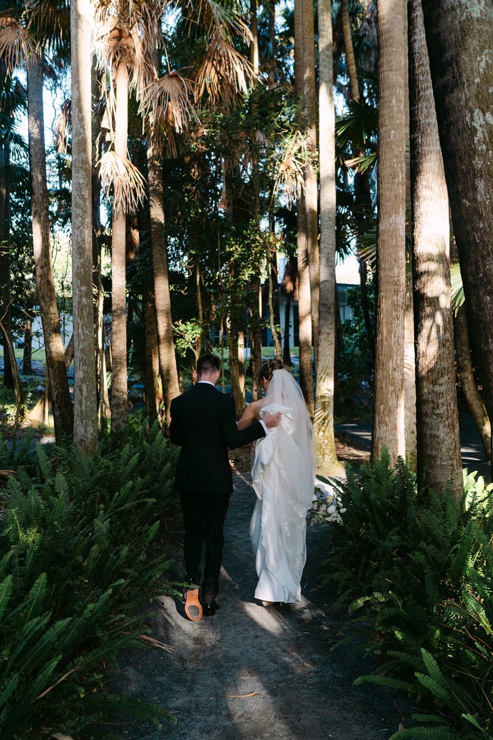 Walking through the tall palms. Demi & Kyle's wedding at Green Cathedral, Pacific Palms, Port Stephens