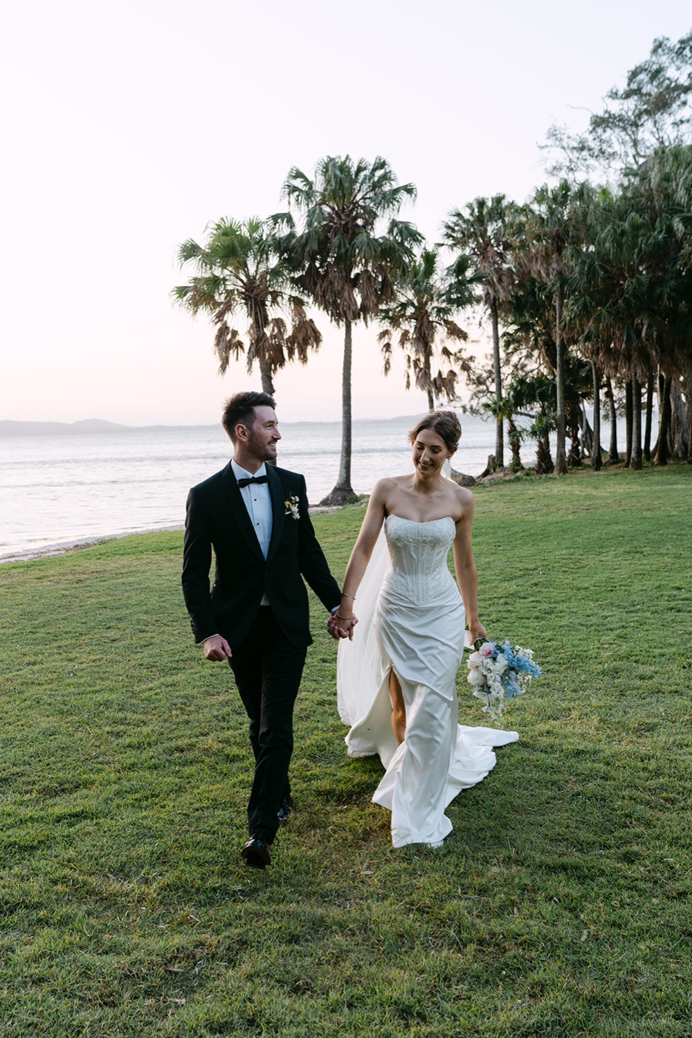 Walking along the lake at sunset. Demi & Kyle's wedding at Green Cathedral, Pacific Palms, Port Stephens