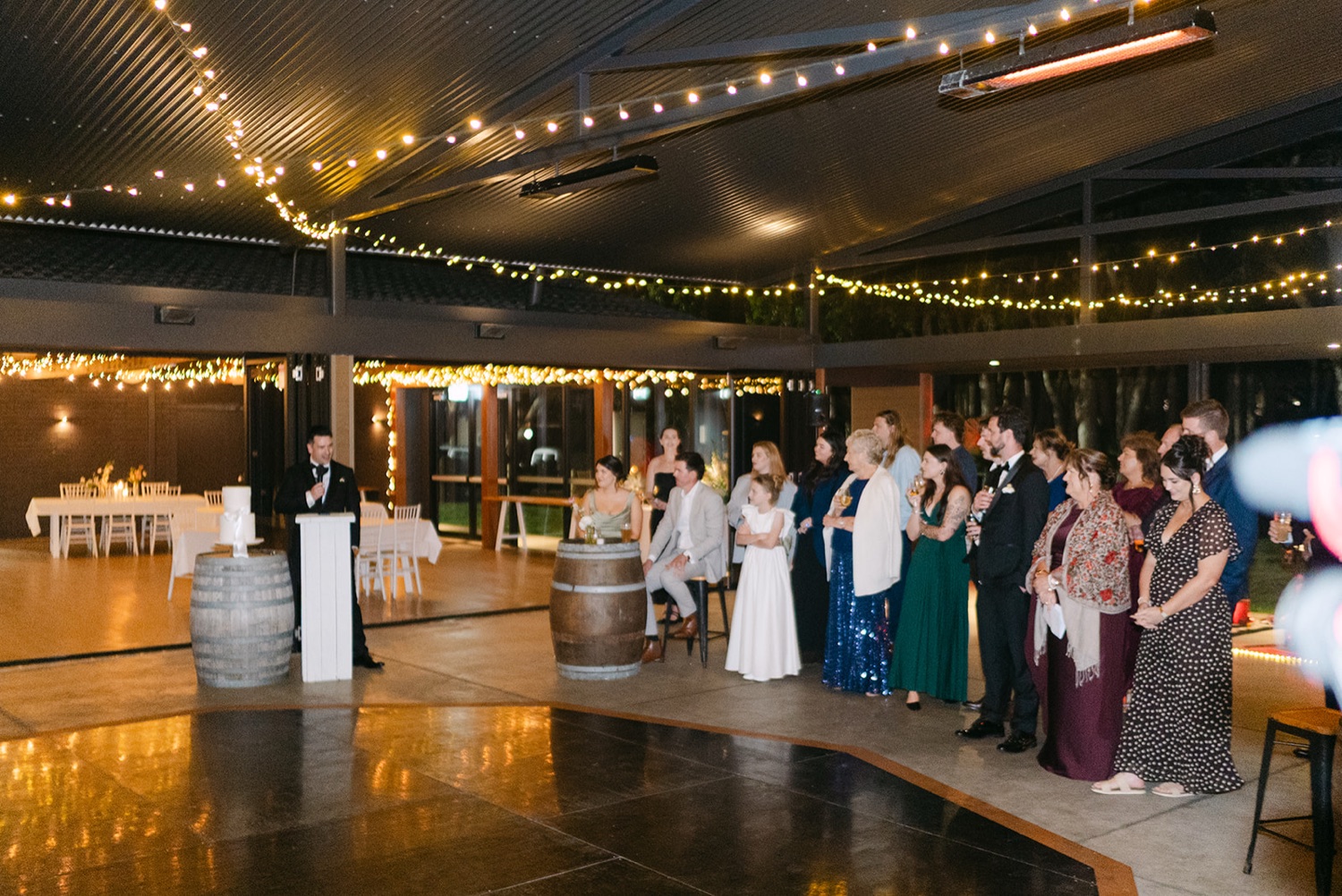 The reception under festoon lights. Demi & Kyle's wedding at Green Cathedral, Pacific Palms, Port Stephens