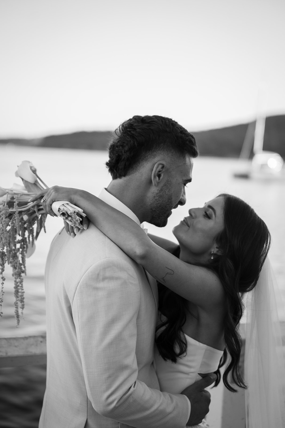 An embrace by the harbour, in black and white. Georgia & Kyle's wedding at Manly Pavilion, Sydney