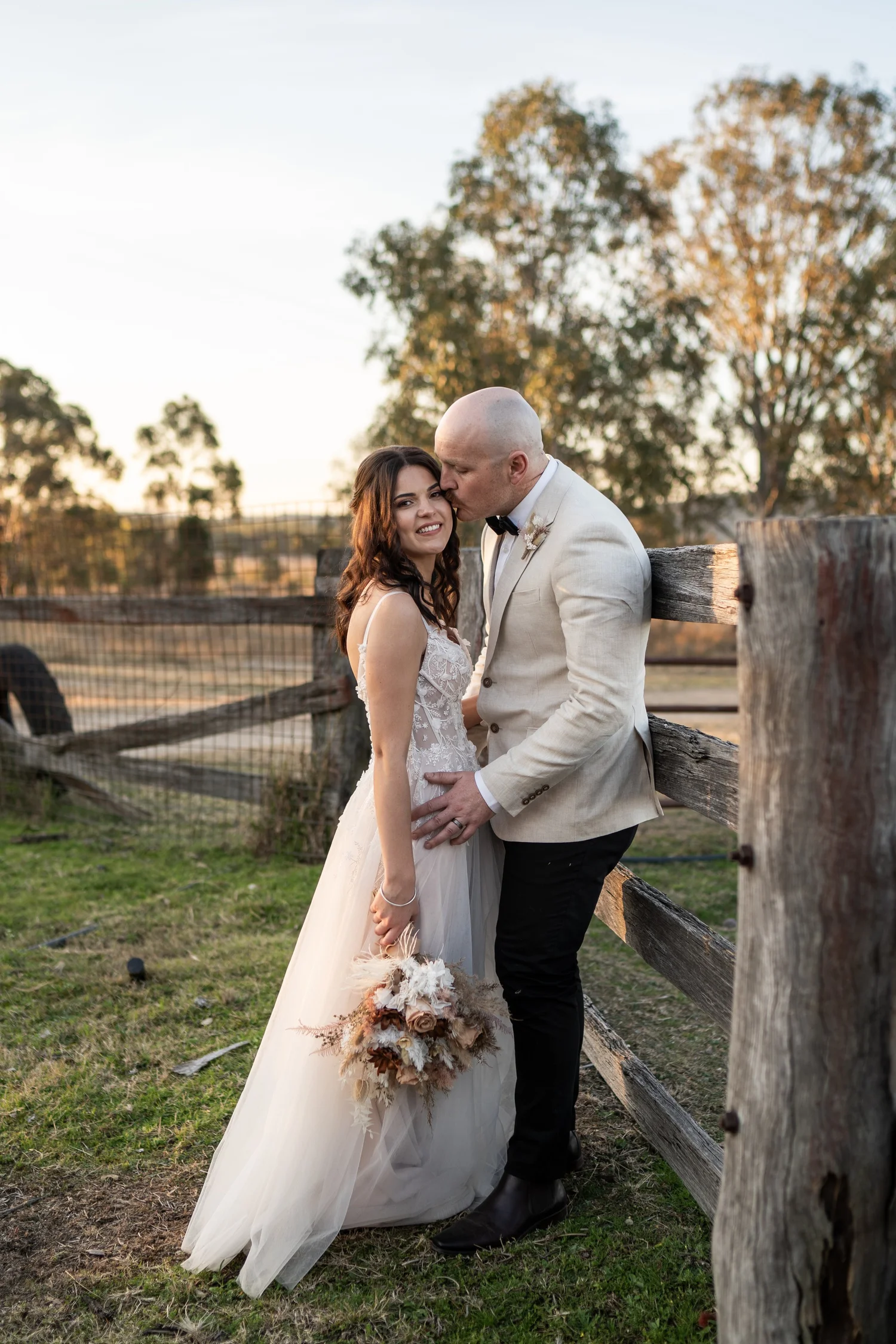 A kiss by the timber fence. Grace & Rhys's wedding at Marlu Station, Hunter Valley