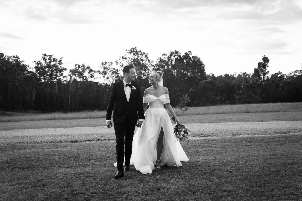 Walking across the paddock, in black and white. Jamie & Corey's wedding at Squire’s Vineyard, Hunter Valley