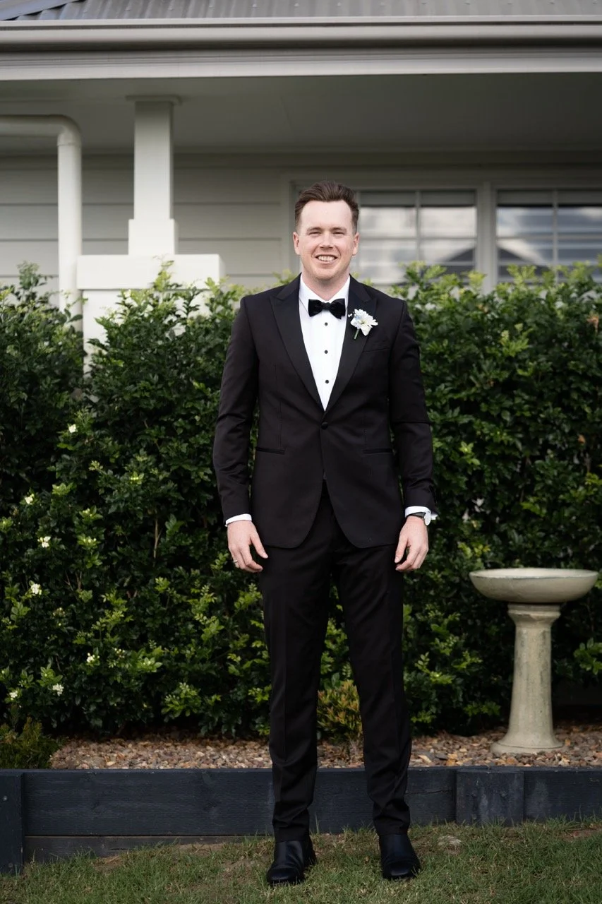 Ready in a black tuxedo by the hedge. Jamie & Corey's wedding at Squire’s Vineyard, Hunter Valley
