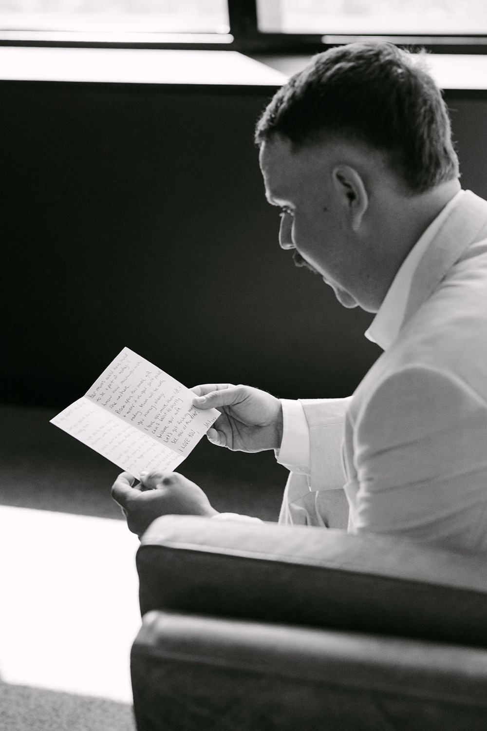 Reading a letter before the ceremony, in black and white. Jasmin & Jye's wedding at Merewether Surfhouse & Ocean Baths, Newcastle