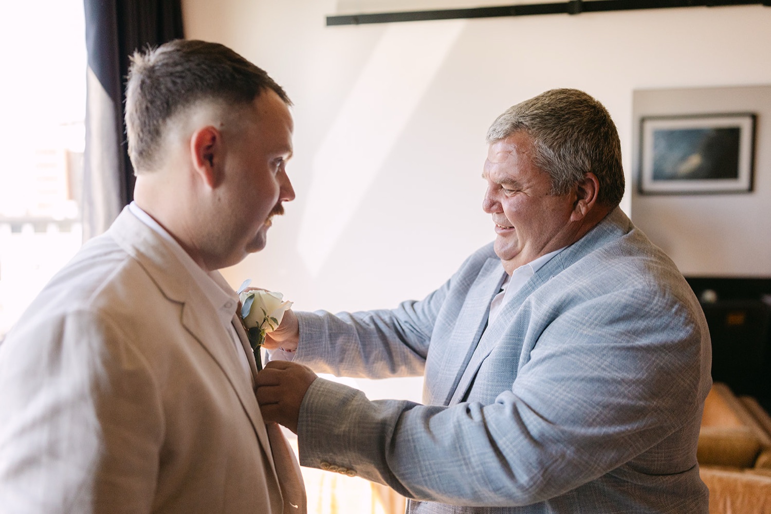 A buttonhole pinned on by family. Jasmin & Jye's wedding at Merewether Surfhouse & Ocean Baths, Newcastle