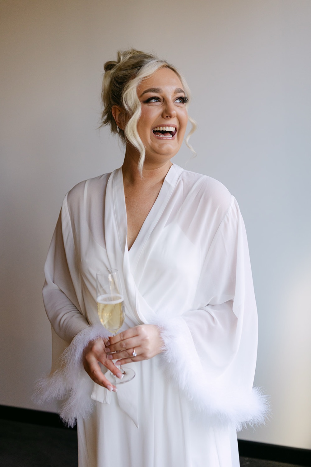 Laughing in a white robe. Jasmin & Jye's wedding at Merewether Surfhouse & Ocean Baths, Newcastle