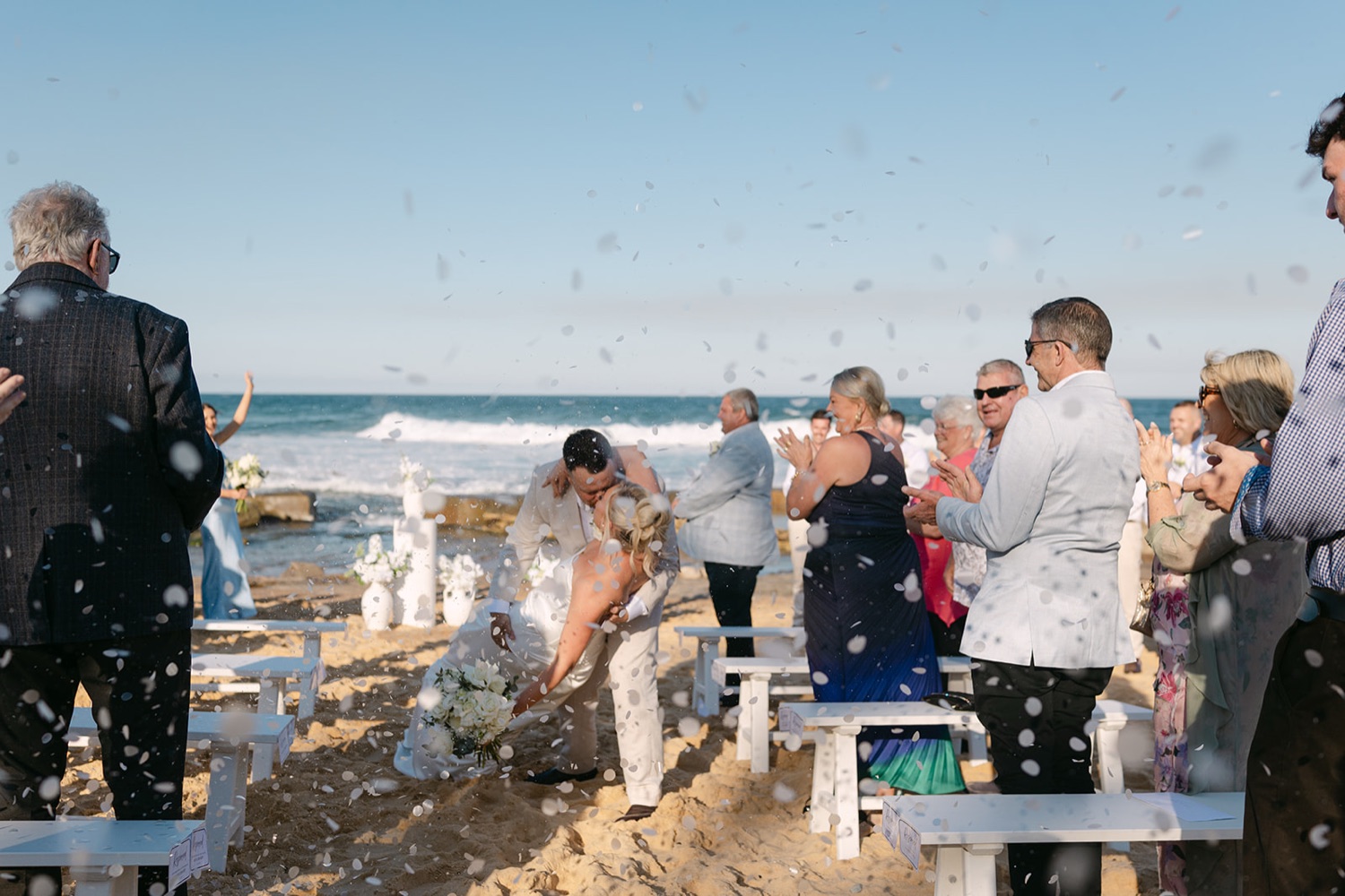 Confetti on the beach. Jasmin & Jye's wedding at Merewether Surfhouse & Ocean Baths, Newcastle