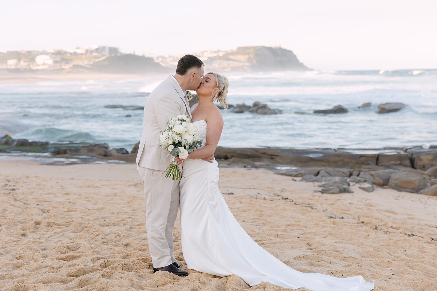 A kiss on the beach. Jasmin & Jye's wedding at Merewether Surfhouse & Ocean Baths, Newcastle
