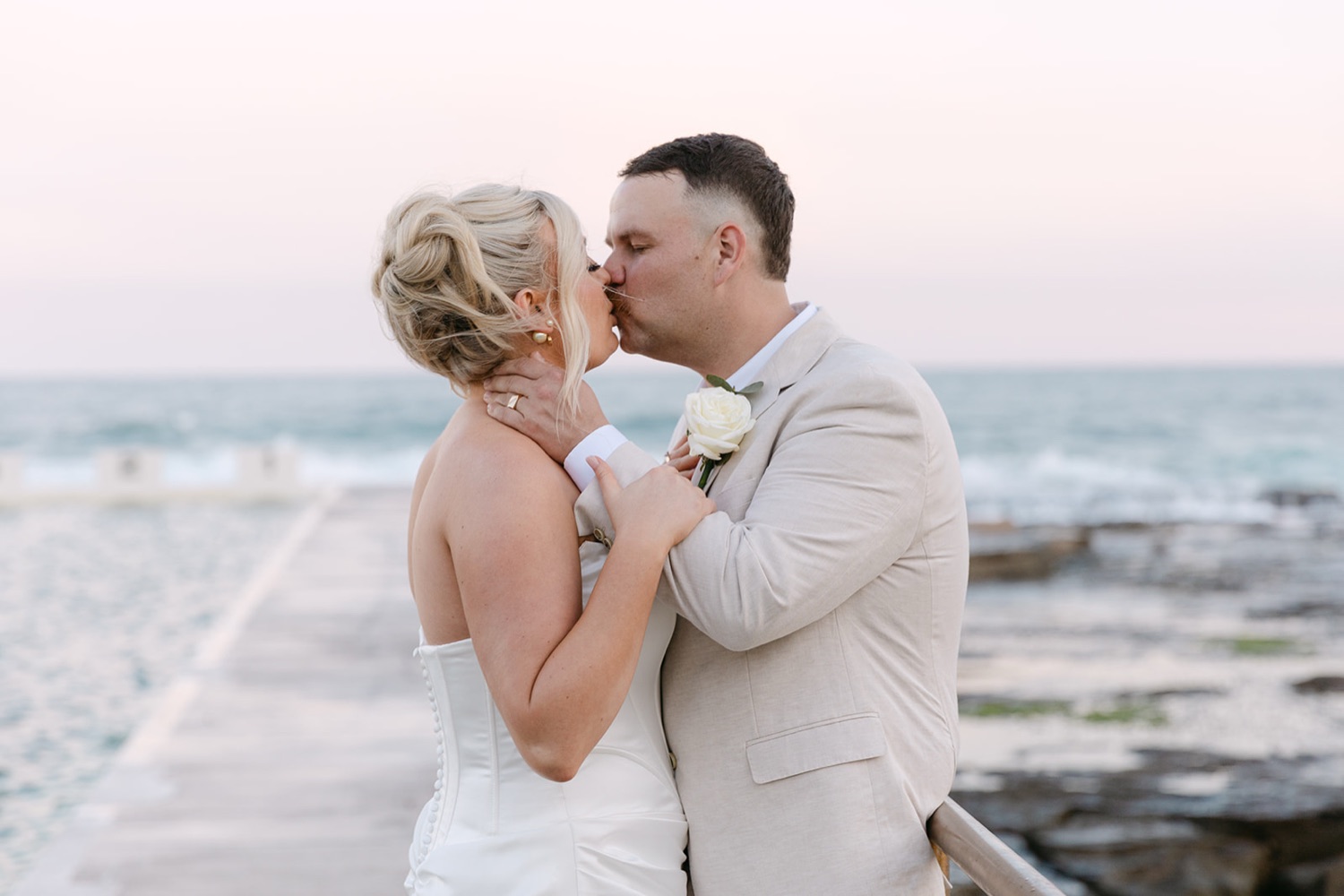 A kiss by the sea at dusk. Jasmin & Jye's wedding at Merewether Surfhouse & Ocean Baths, Newcastle