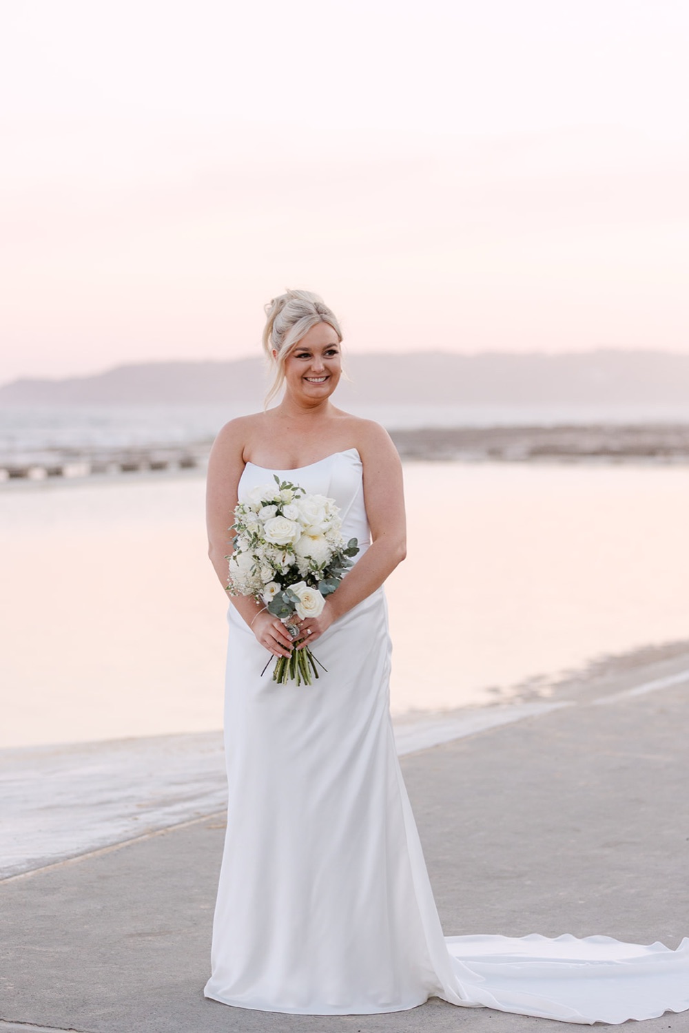 Portrait with the bouquet at the ocean baths. Jasmin & Jye's wedding at Merewether Surfhouse & Ocean Baths, Newcastle