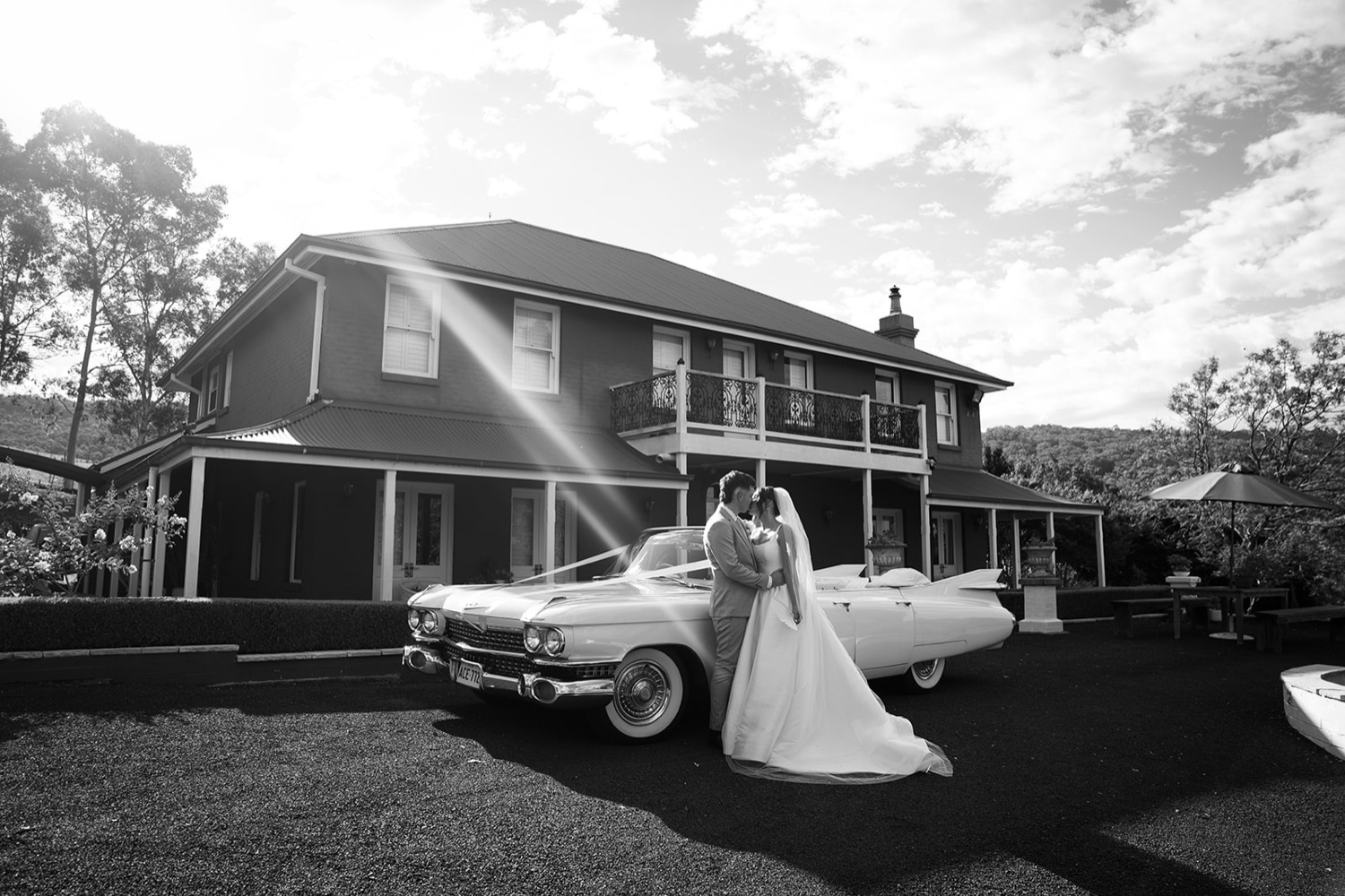 A vintage car outside the house, in black and white. Jasmine & Joshua's wedding at The Lakehouse, North Richmond, Sydney