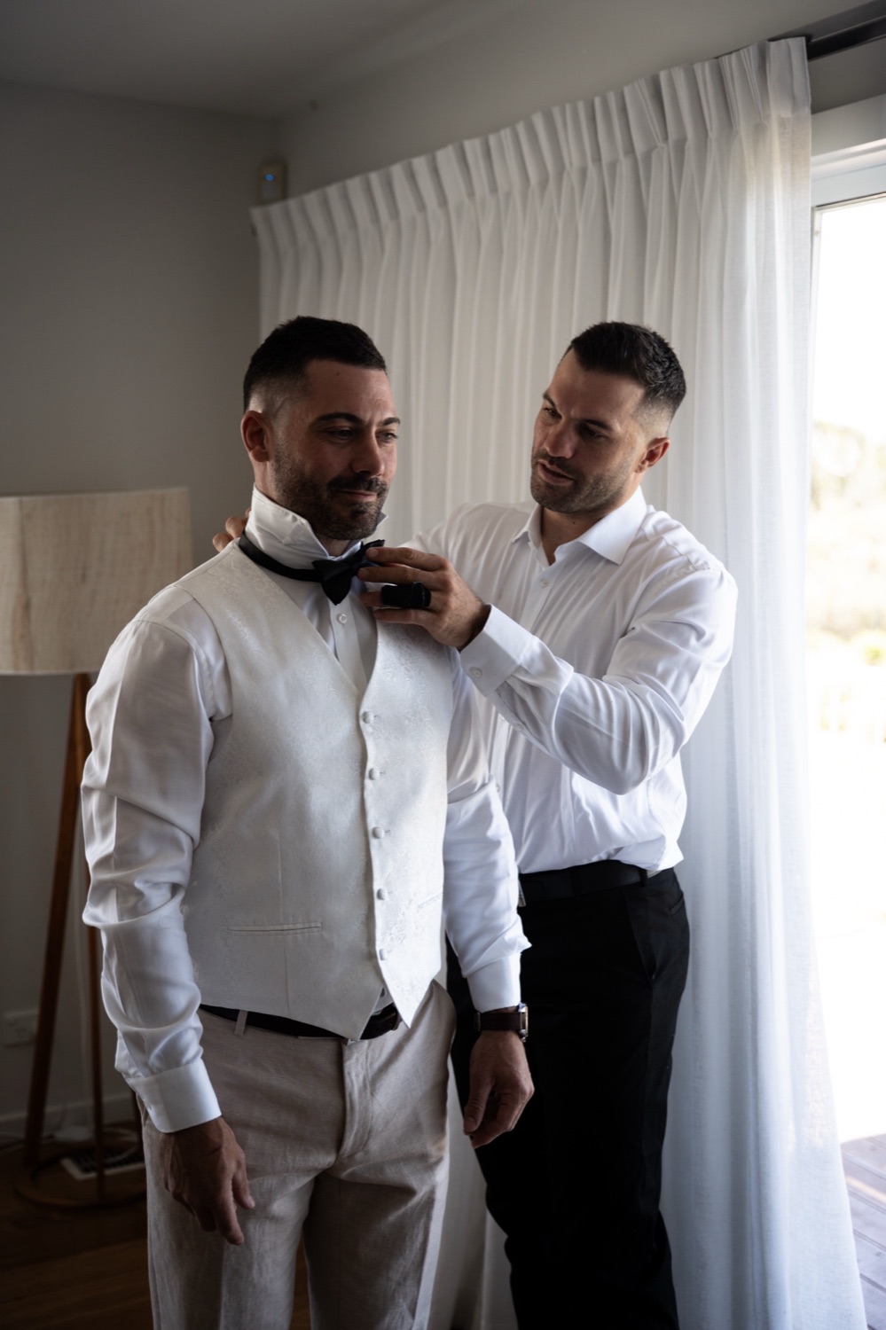 A bow tie straightened before the ceremony. Jemma & Matthew's wedding at Caves Coastal Bar & Bungalows, Newcastle