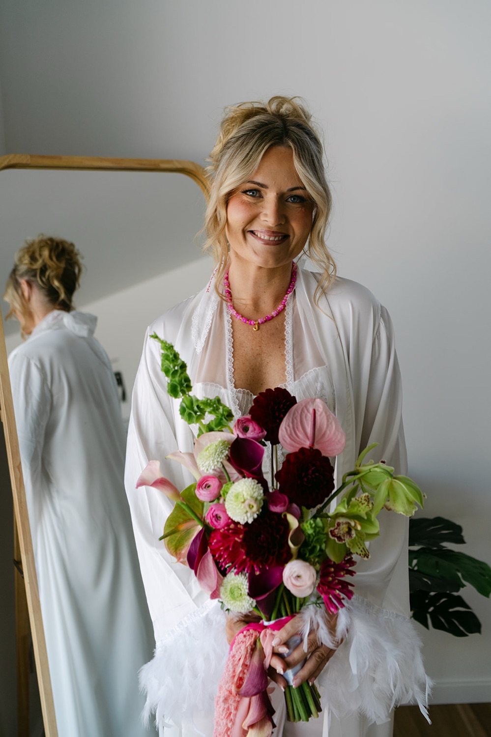 Ready with a bouquet of red and white flowers. Jessica & Ricky's wedding at Chapel of Light, Port Stephens