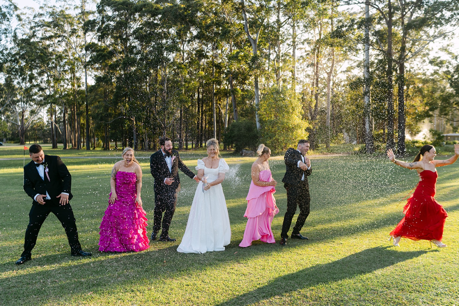 The wedding party having fun on the lawn. Jessica & Ricky's wedding at Chapel of Light, Port Stephens