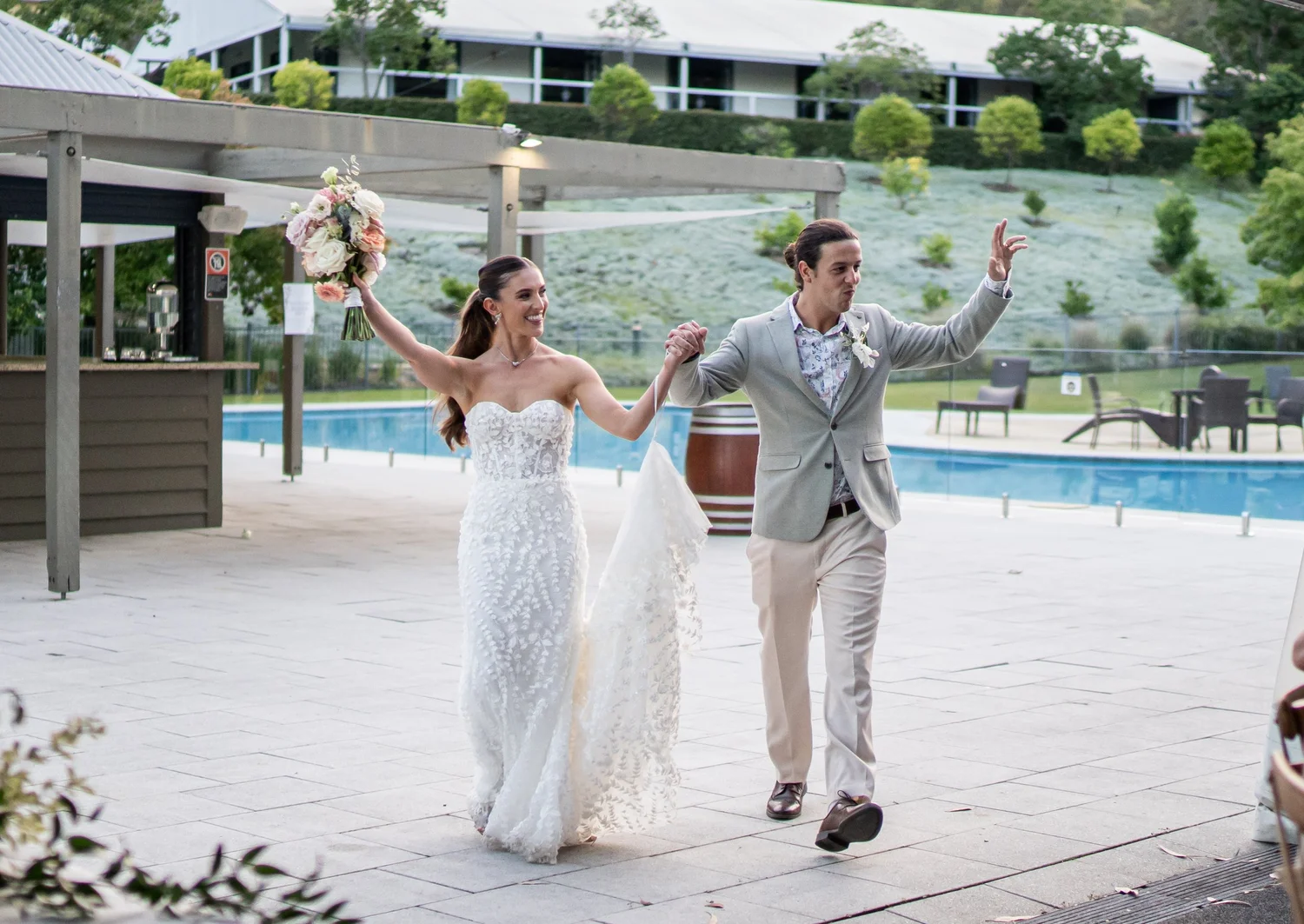 A grand entrance by the pool. Kaitlin & James's wedding at Oaks Cypress Lakes Resort, Hunter Valley