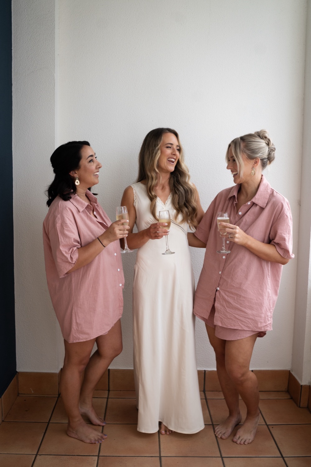 Getting ready in matching pink robes. Lauren & Alasdair's wedding at Shoal Bay Beach, Port Stephens