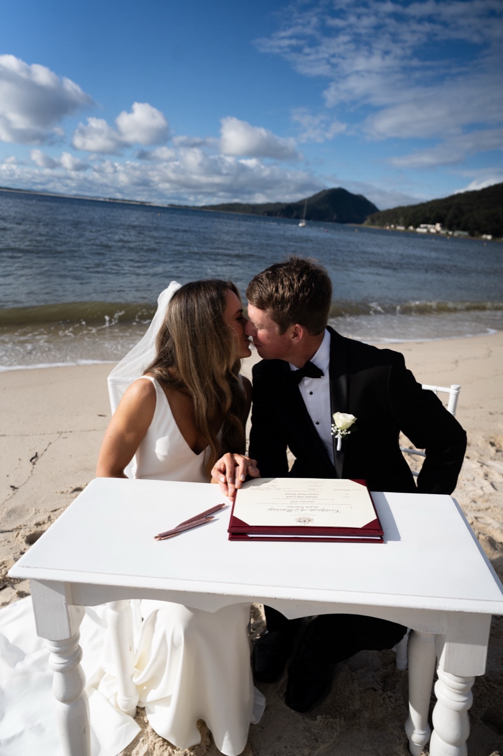 Signing the register on the beach. Lauren & Alasdair's wedding at Shoal Bay Beach, Port Stephens