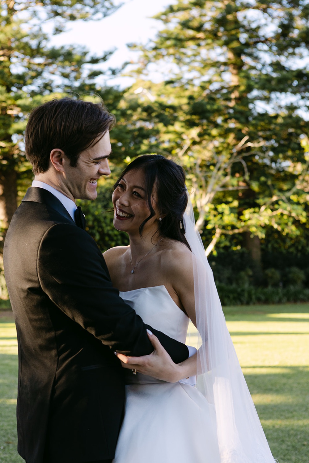 A close embrace on the lawn. Phoebe & Cameron's wedding at Curzon Hall, Sydney