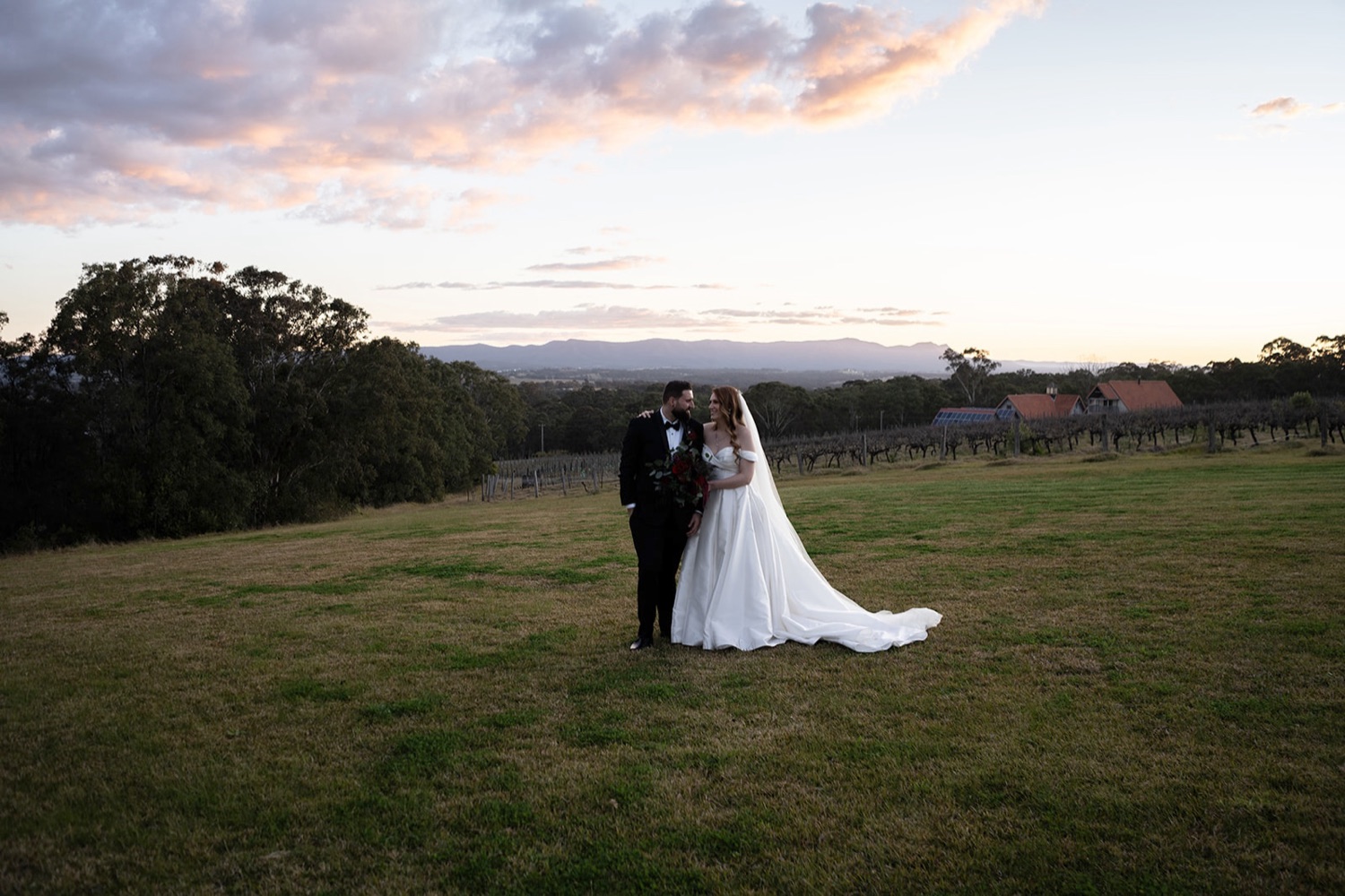 The couple on the hill with the valley behind. Sarah & Alex's wedding at Wandin Estate, Hunter Valley