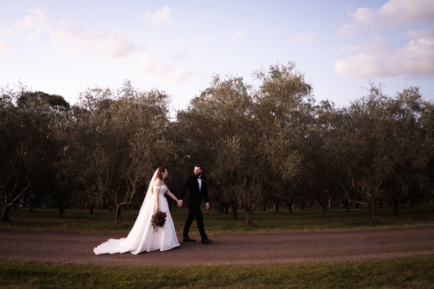 Walking across the lawn at dusk. Sarah & Alex's wedding at Wandin Estate, Hunter Valley