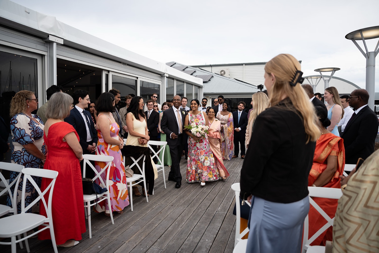 Guests at the ceremony on the deck. Seneli & Grayson's wedding at Lake Macquarie Yacht Club, Belmont, Newcastle
