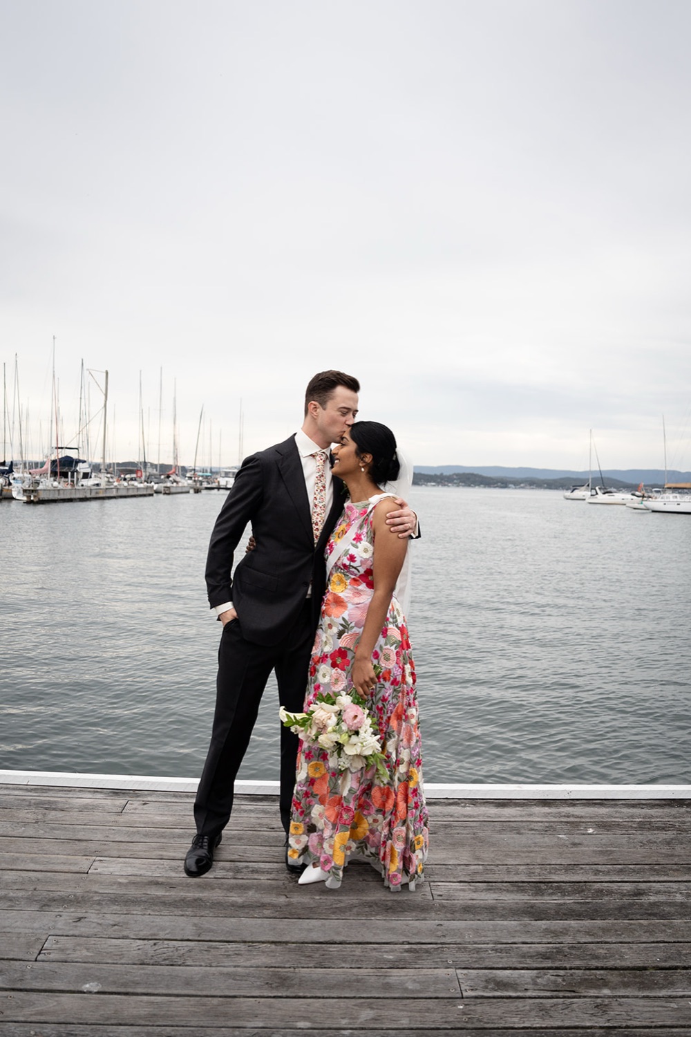 The couple on the jetty. Seneli & Grayson's wedding at Lake Macquarie Yacht Club, Belmont, Newcastle