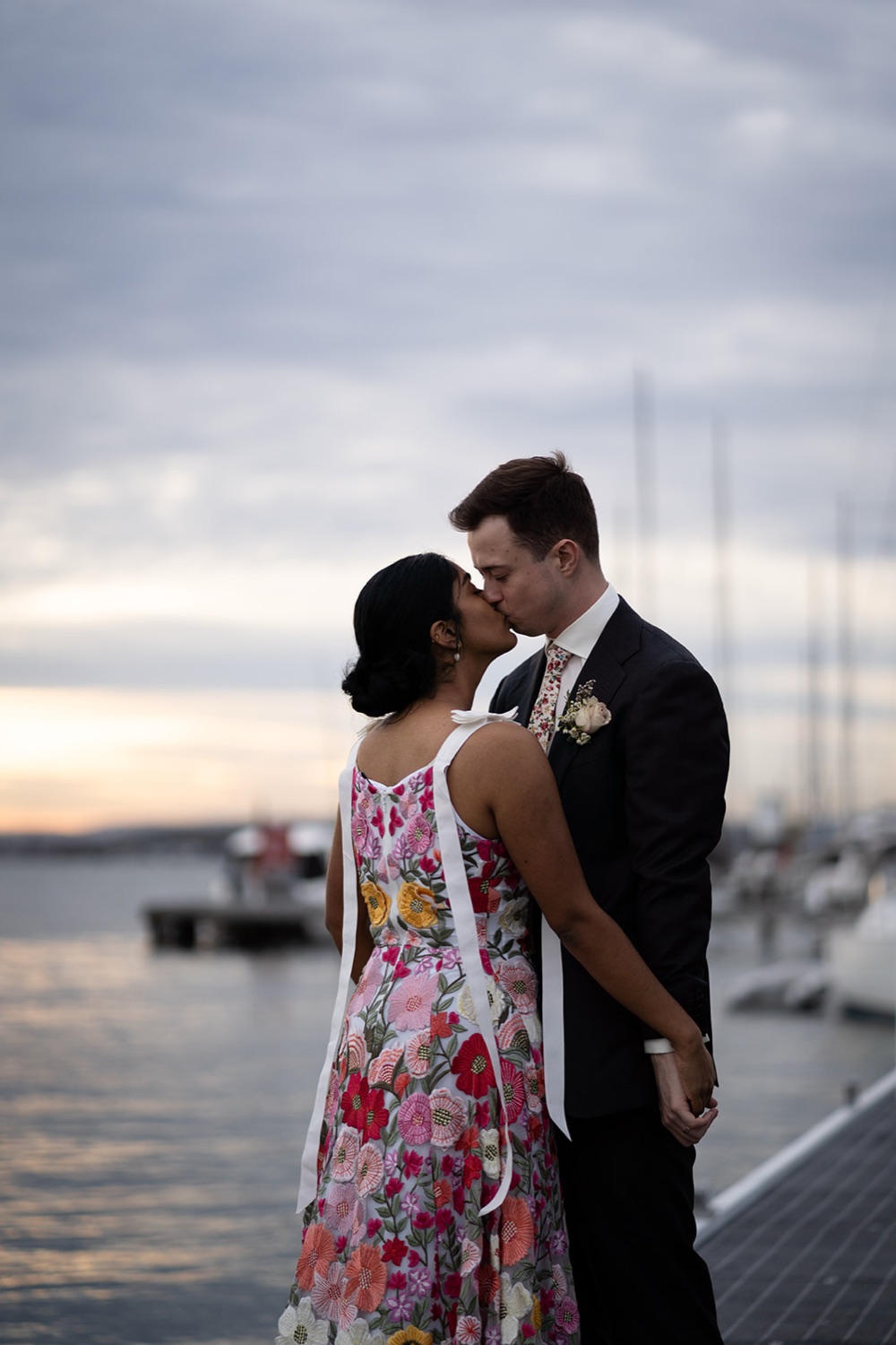 A kiss by the marina at dusk. Seneli & Grayson's wedding at Lake Macquarie Yacht Club, Belmont, Newcastle