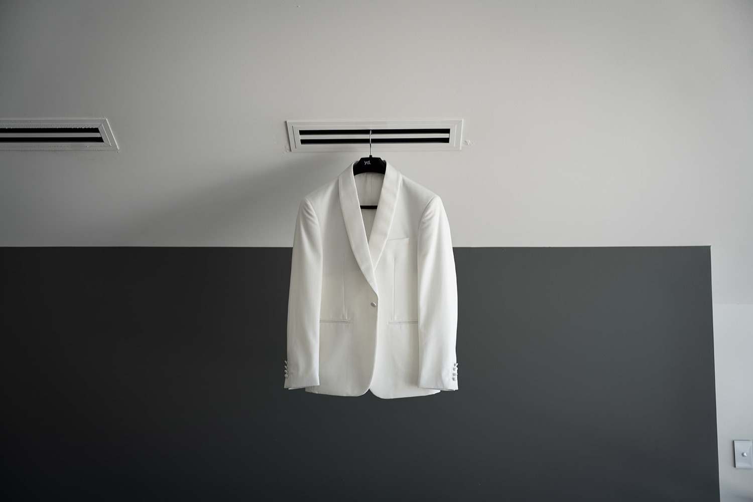 A white dinner jacket hanging up. Sophie & Benjamin's wedding at Caves Coastal Bar & Bungalows, Newcastle