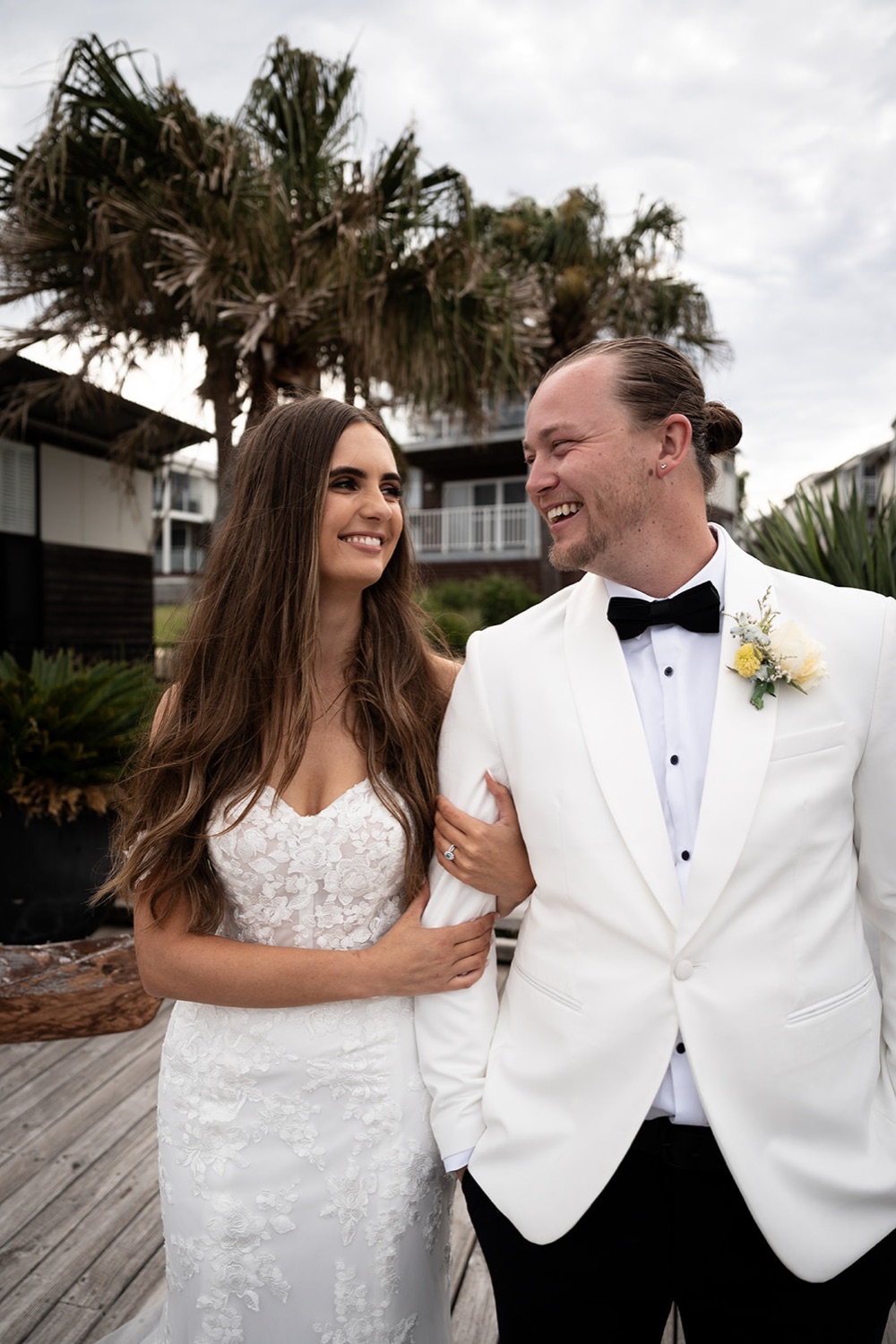 Smiling together under the palms. Sophie & Benjamin's wedding at Caves Coastal Bar & Bungalows, Newcastle