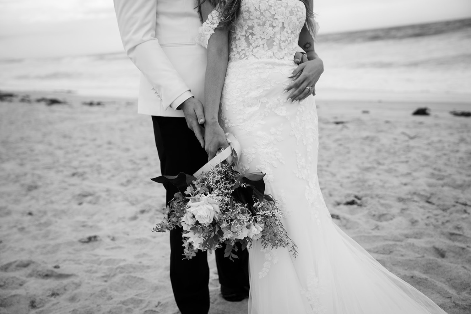 Holding the bouquet, in black and white. Sophie & Benjamin's wedding at Caves Coastal Bar & Bungalows, Newcastle