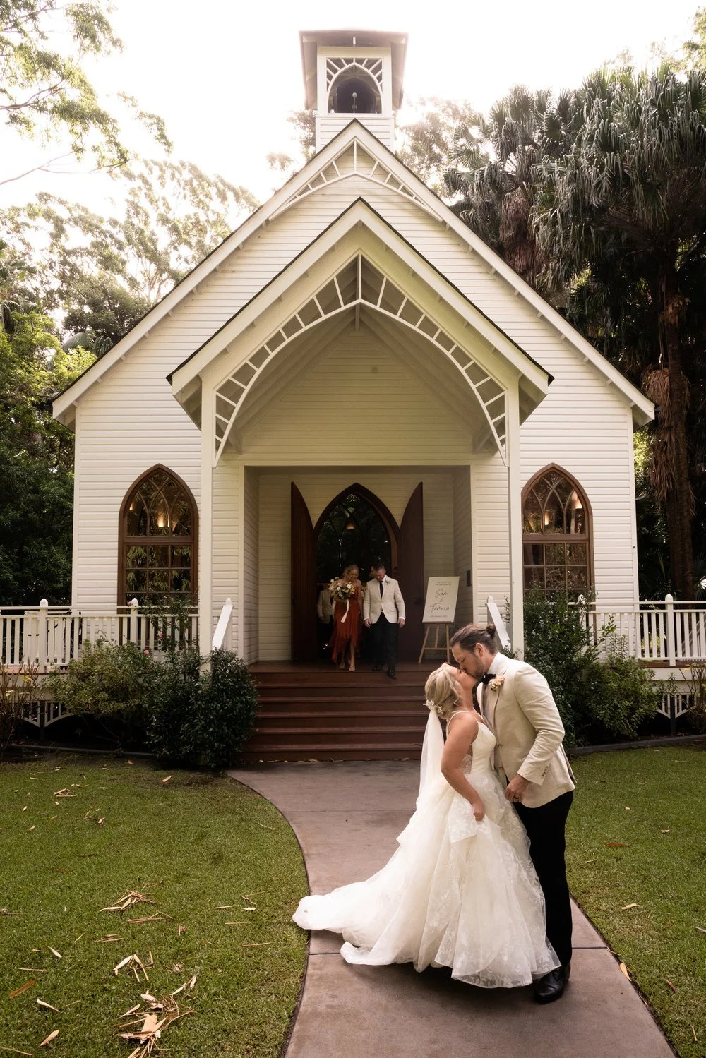 The couple outside the white chapel. Tamara & Sam's wedding at Kantara House, Central Coast