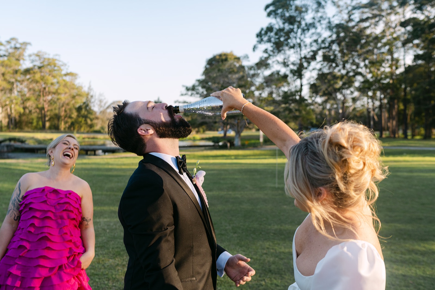Celebrating with friends on the lawn. Jessica & Ricky's wedding at Chapel of Light, Port Stephens