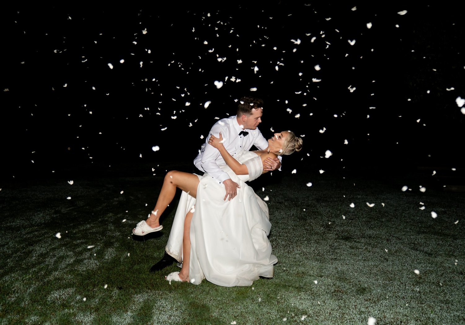 A dip under falling confetti at night. 's wedding at unknown, unknown