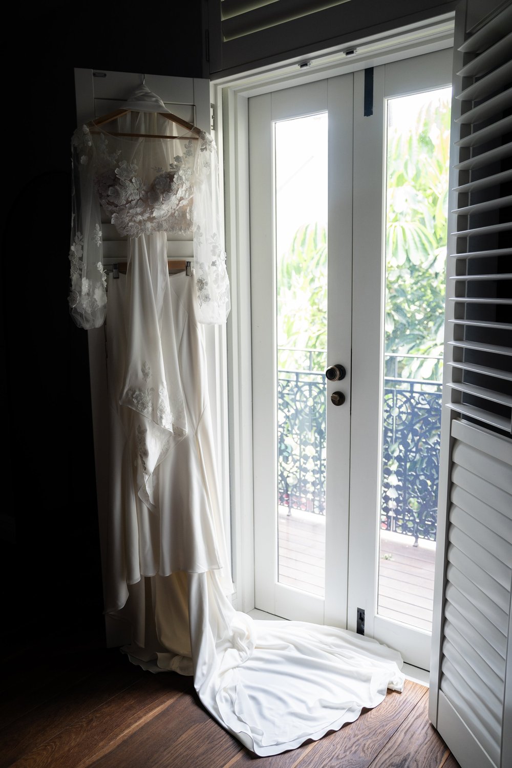 The wedding dress by the window shutters